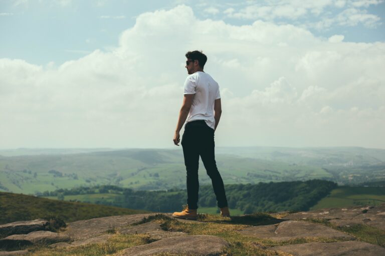 Man standing on mountain looking across the valleys.