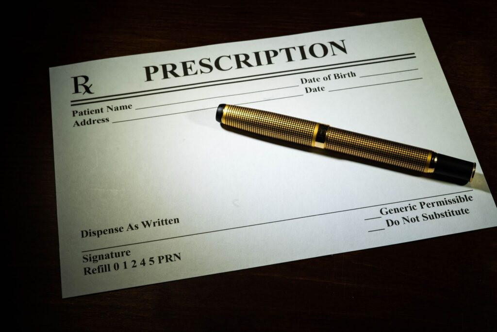 A prescription notepad with a pen on top.