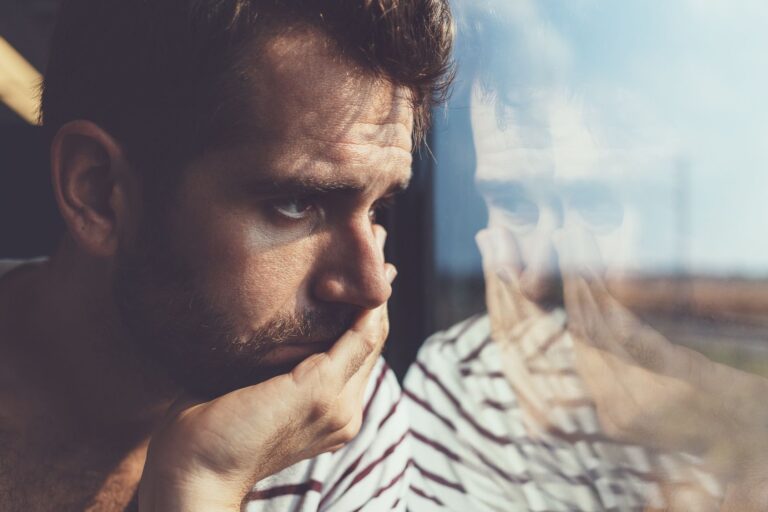 A man thinking while he looks out of a vehicle.