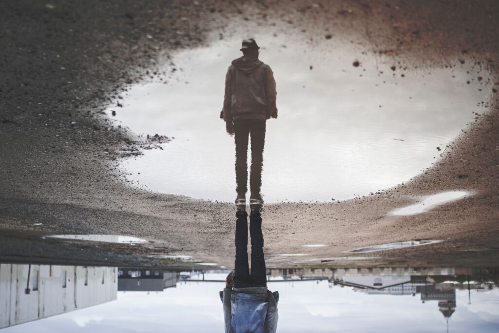 man standing in puddle with reflection