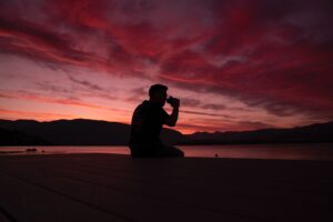 man drinking on beach