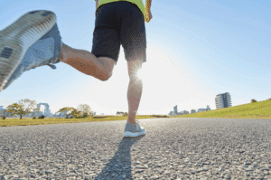 Runner's legs mid-stride on a sunny city-park morning run